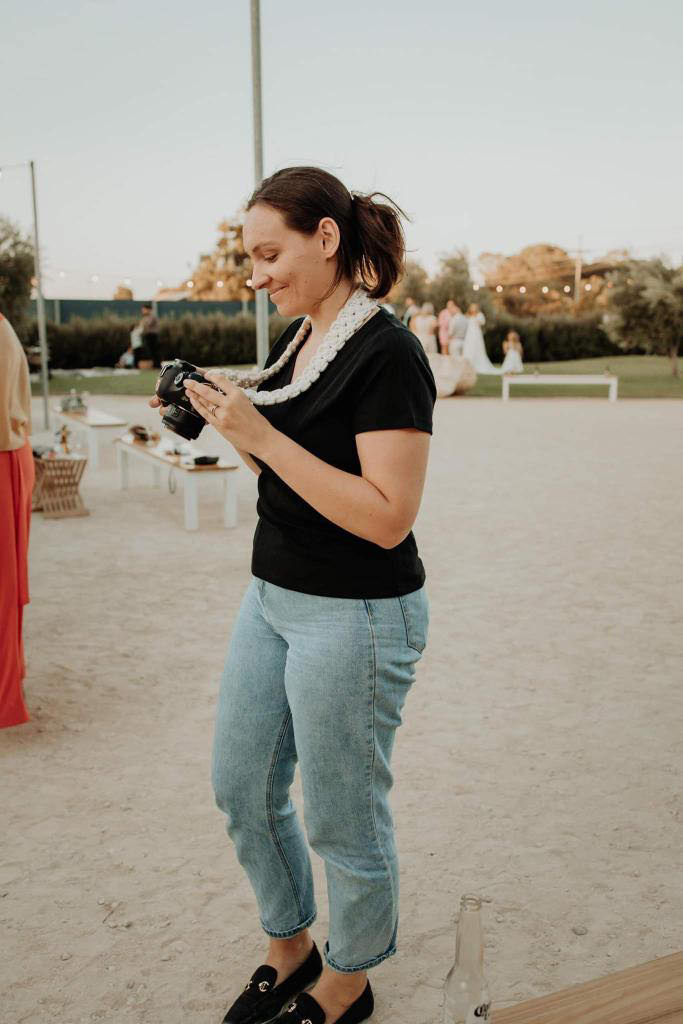 Side-profile-of-photographer-scrolling-in-camera-at-photos-just-taken-and-smiling